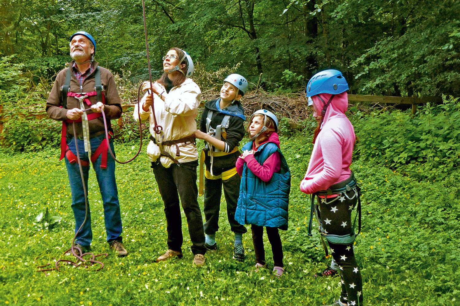 Zwei Erwachsene und zwei Kinder im Klettergarten.