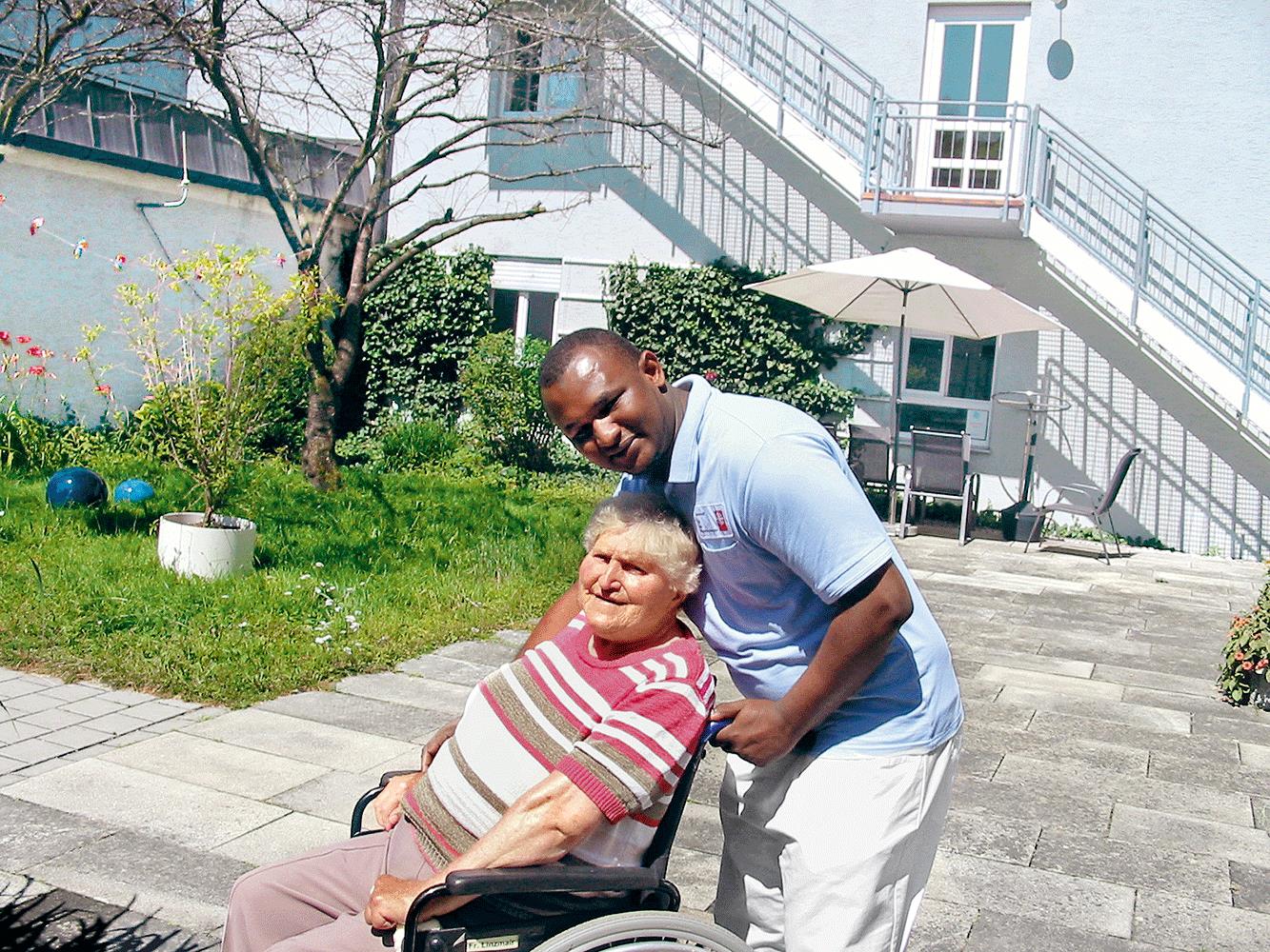 Krankenpfleger mit alter Frau im Rollstuhl