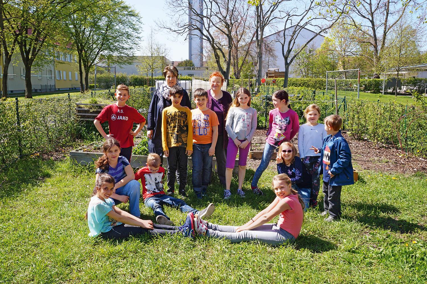 Gruppenbild, auf dem rund zehn Kinder und zwei ältere Frauen im Grünen stehen