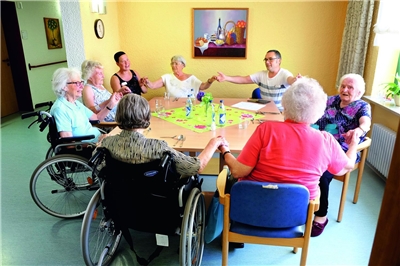 Altenheimrunde - Wünsch dir ein Lied Eine Runde von Heimbewohnerinnen und Betreuer fasst sich an den Händen.