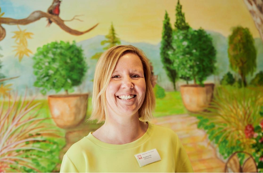 Die Heimleiterin Susanne Uhl vor einer bunt bemalten Wand.