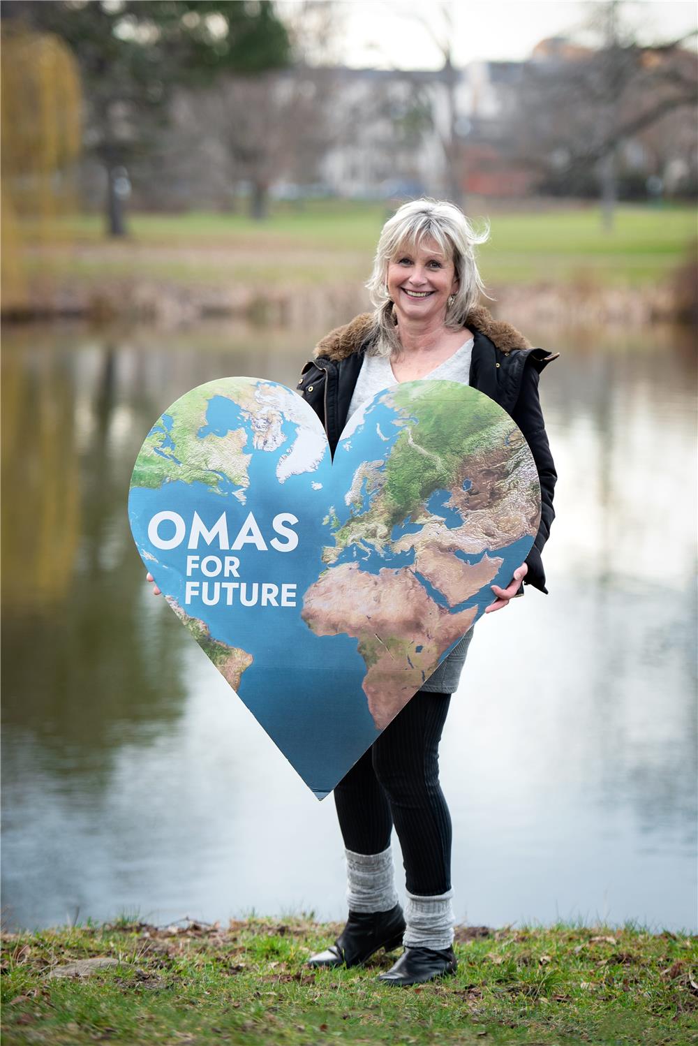 Cordula Weimann hält ein Schild der Omas for Future hoch