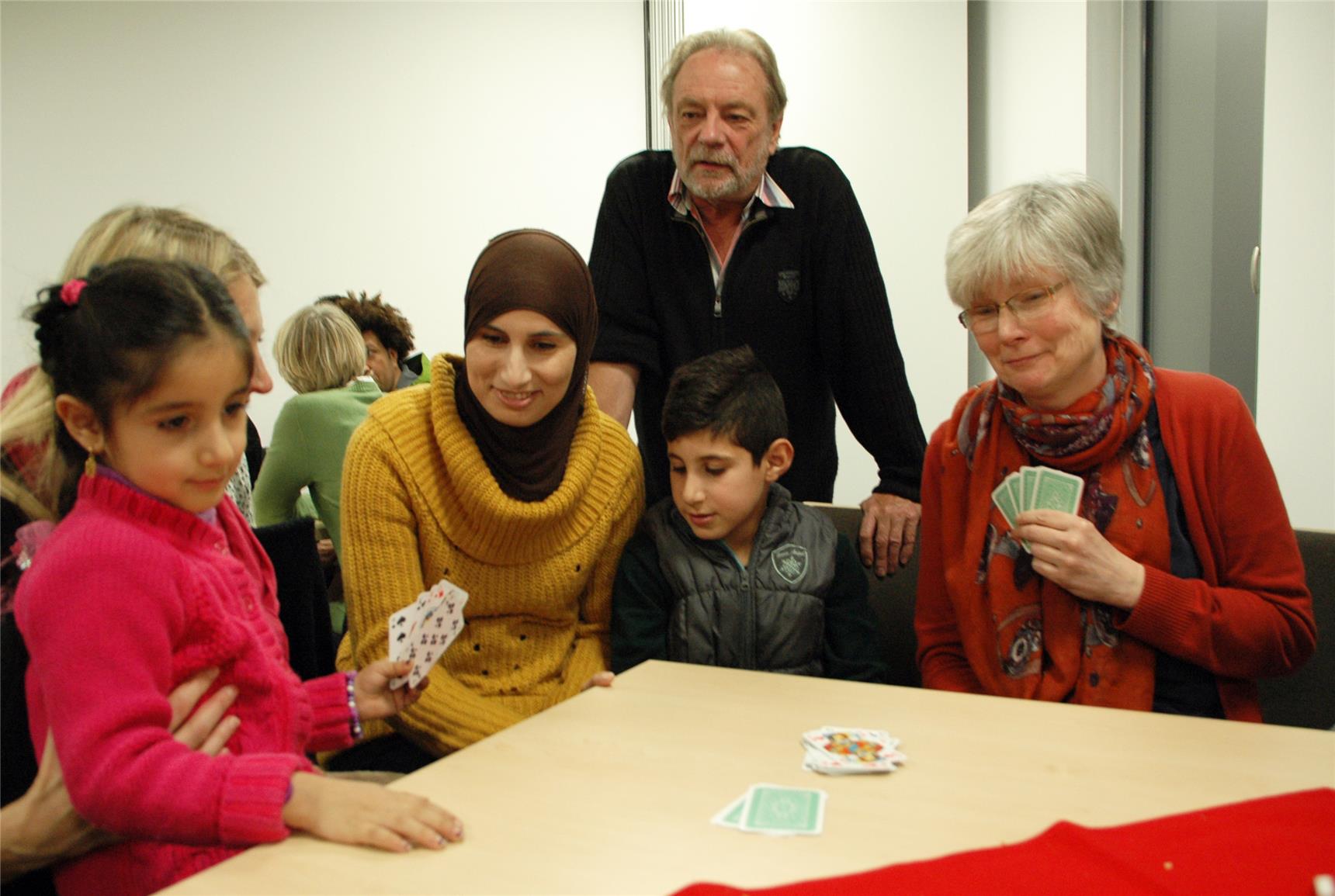 Auf dem Bild spielen mehrere Erwachsene mit Kindern