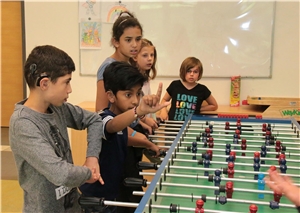 Jungs unter sich Mehrere Kinder stehen um ein Tischfußball spiel