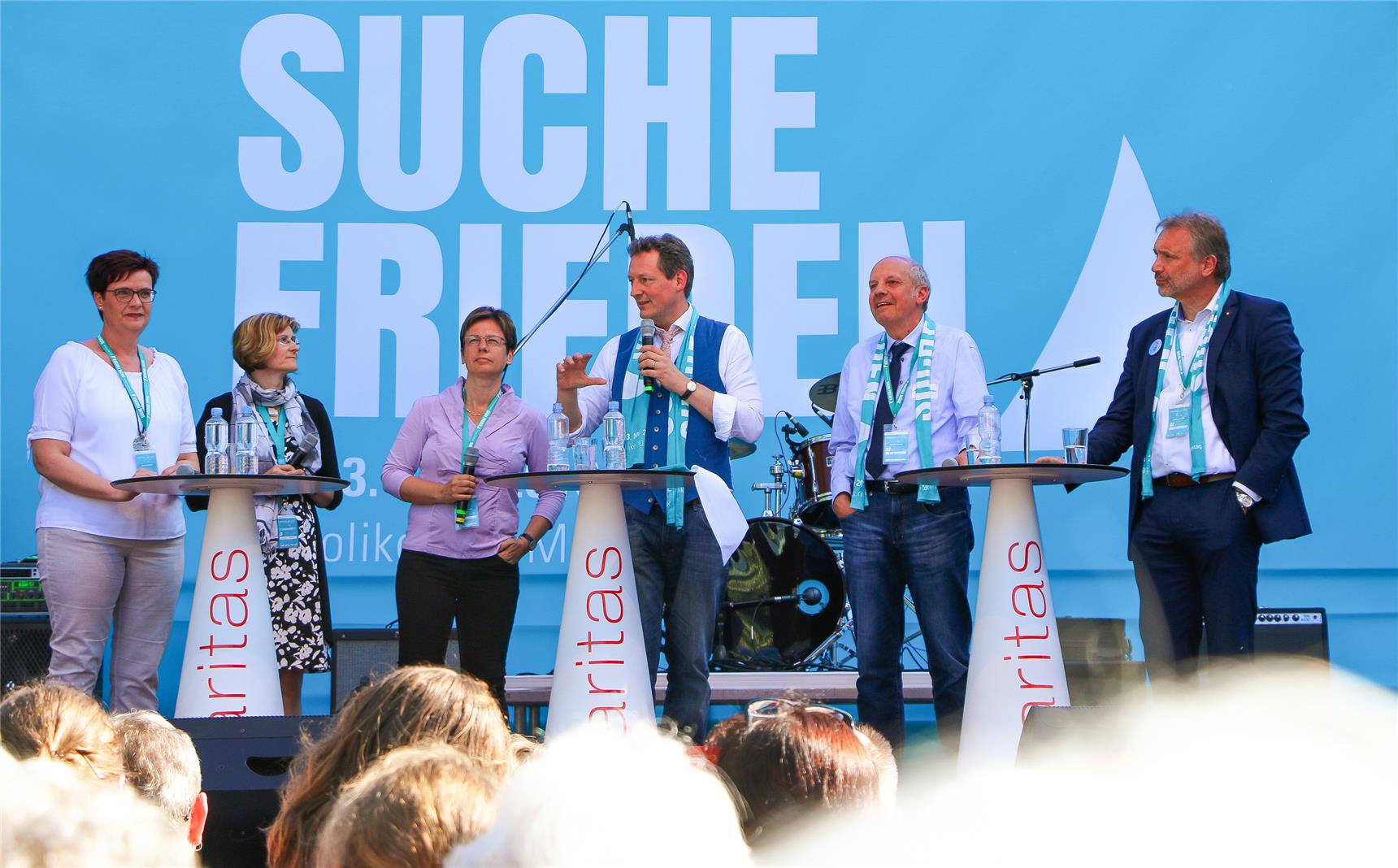 Auf der Bühne stehen mehrere Menschen und diskutieren