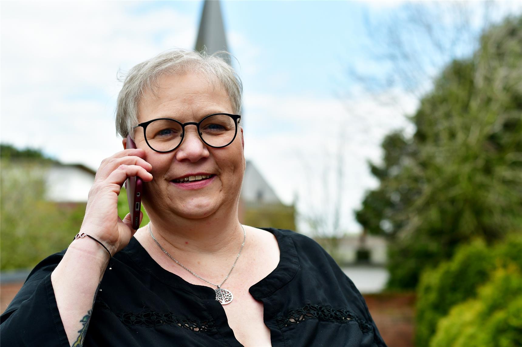 Das Foto zeigt eine Frau, die ein Handy ans Ohr hält.