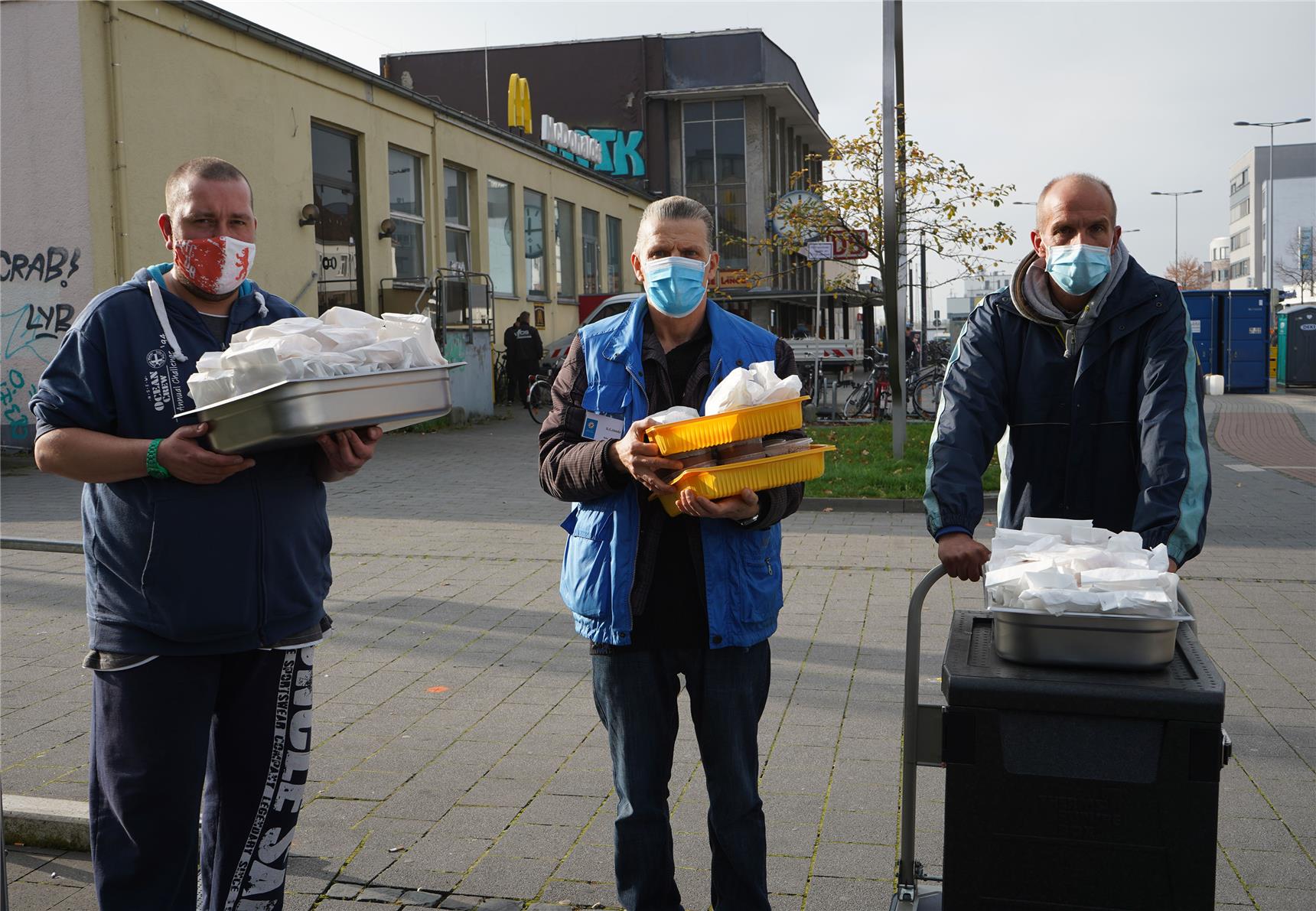 Mitarbeiter der Bahnhofsmission bringen die rund 100 Portionen des frisch gekochten Essens zu den auf Gleis 1 wartenden Bedürftigen. 