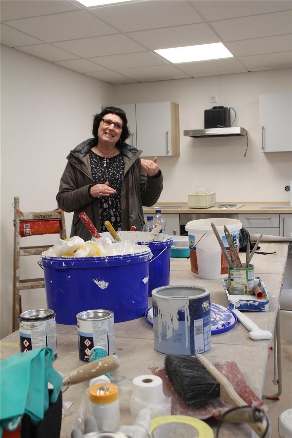 Regina Bergmann, Geschäftsführerin des SkF Trier, steht im Rohbau vor einem Tisch mit Handwerkermaterialien.  Baustellenbesuch. 