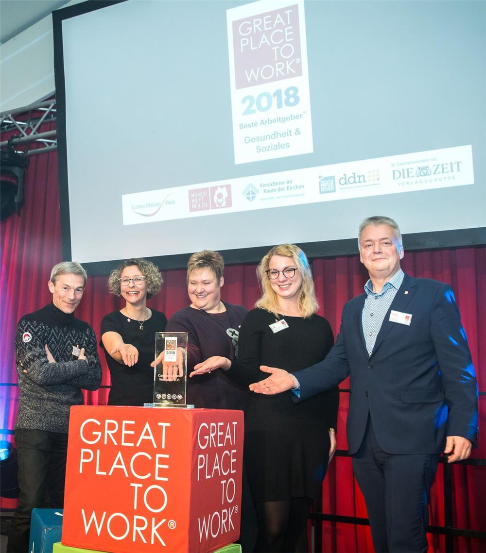 Auf dem Bild stehen die Gewinner des Great Place to work vom Caritasverband Westeifel mit ihrer Auszeichnung.