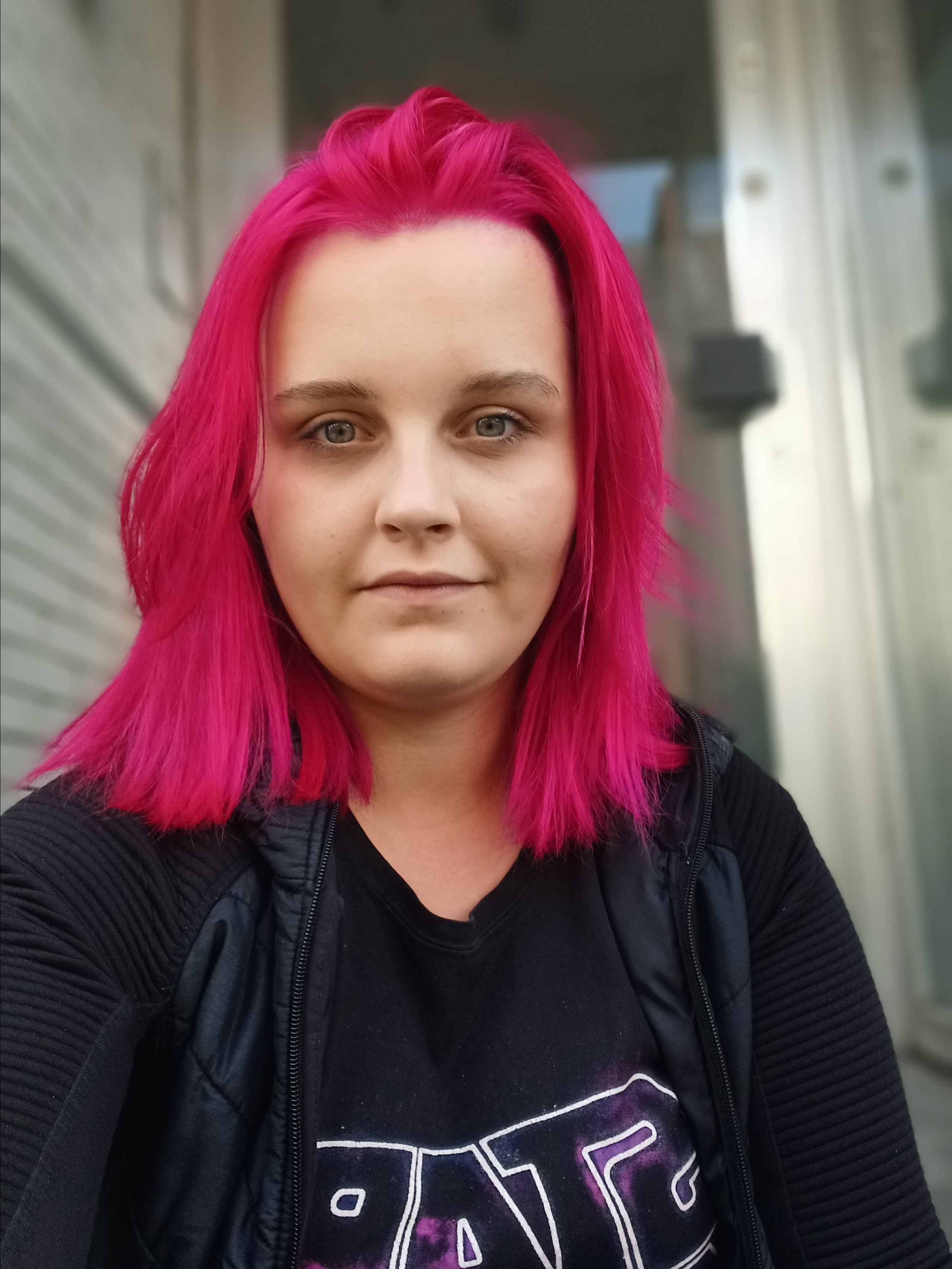 Portrait einer jungen Frau mit pink gefärbten Haaren