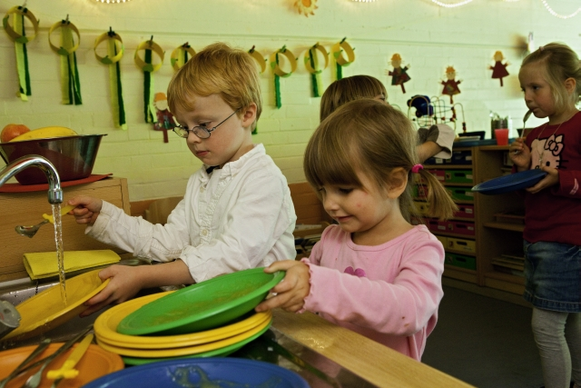 Kinder in der Küche beim abspülen