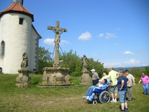 2011_03_02_kreuz Die Gruppe befindet sich auf einer Anhöhe. Vor einem Wegkreuz sucht die Gruppe Erholung in einem Spi