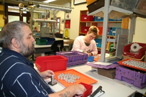 Werkstatt_01 Hier sehen wir einen Werkstattarbeiter, der Gewindeschrauben zusammensteckt.