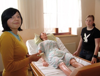 Zwei Schülerinnen üben an der Pflegepuppe