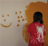 Wirkung der Farbgestaltung Eine Jugendliche beim Streichen der Wand