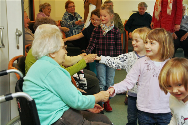Auf dem Foto geben die Kinder den älteren Damen die Hand