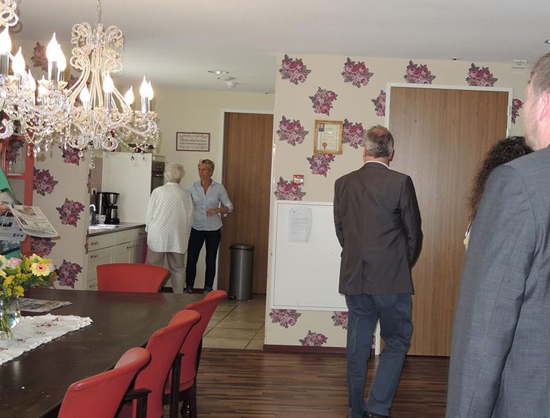 Wir befinden uns in einem gegliederten Mehrzweckraum. Im Vorderteil ist ein Speiseraum mit alten Möbeln insbesondere sehr verzierten Kronleuchtern und Mustertapete eingerichtet. Im hinteren Teil ist e