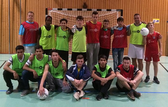 In einer Sporthalle haben sich die unbegleiteten minderjährigen Aussiedler mit Ihren Trainern im Fußballtor zu einer Gruppe zusammen gestellt.