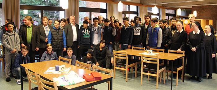 Alle Anwesenden beim Adventscafe haben sich in mehreren Reihen bunt gemischt zu einer Gruppe aufgestellt.