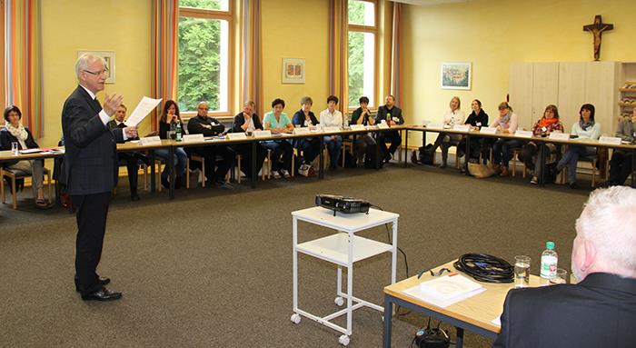 In der Aula des Bonifatiusklosters in Hünfeld referiert unser Generalvikar. Im großen Raum nahmen viele Teilnehmer an einem im U-Format gestellten Tisch Platz. Wir schauen Prof. Stanke seitlich an und