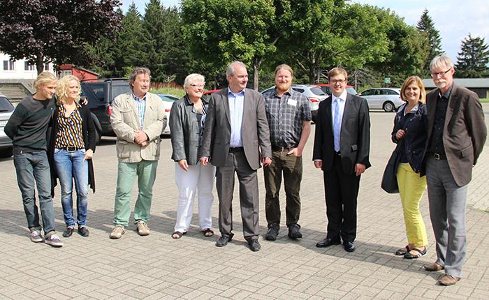 Wir befinden uns auf einem Parkplatz auf der Wasserkuppe. Bei schönem Wetter haben sich die Teilnehmer des Treffens im Halbkreis zu einer Gruppe zusammengestellt. 