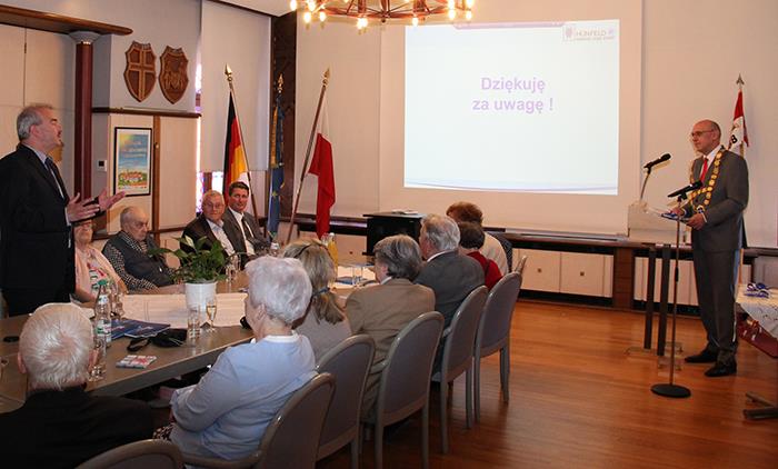 Wir blicken auf die Gesprächsrunde im Rathaus. Alle Anwesenden sitzen an einem großen ovalen Tisch.