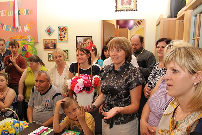 Viele Eltern haben sich in einem hellen Raum versammelt.