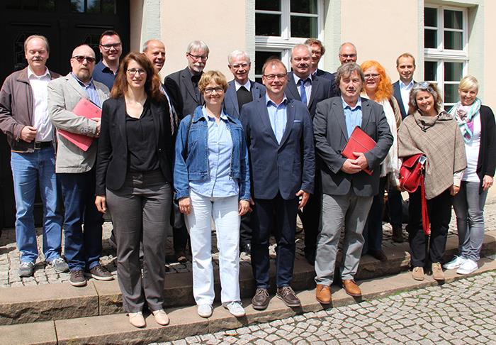 Die Teilnehmer des Netzwerkes haben sich vor der Geschäftsstelle zu einem Gruppenfoto zusammen gestellt.