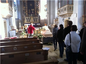 Trauergeleit Menschen geben einem Toten die letzte Ehre. Sie treten vor einen Sarg und segen den Toten mit Weihwasser.