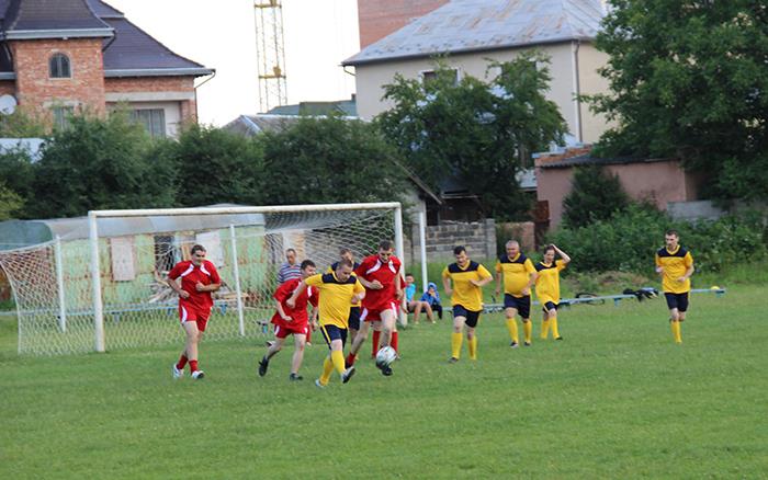 Wir sind zu Gast bei einem Fußballspiel. Behinderte Menschen in roten und gelben Trikots spielen gegeneinander.