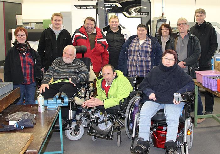 Vor der CNC Maschine haben sich die Teilnehmer zu einem Gruppenfoto aufgestellt.