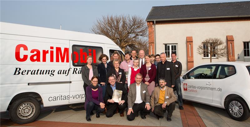 Vor dem CariMobil stehen Caritas-Mitarbeitende 
