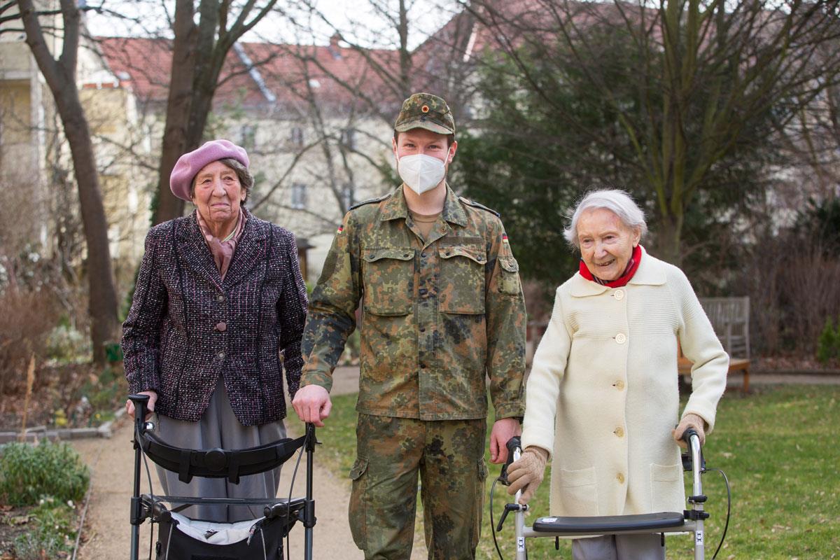 Soldat geht spazieren mit Bewohnerinnen