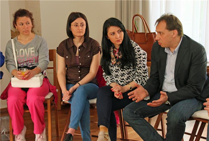 Das Bild zeigt vier sitzende Personen.