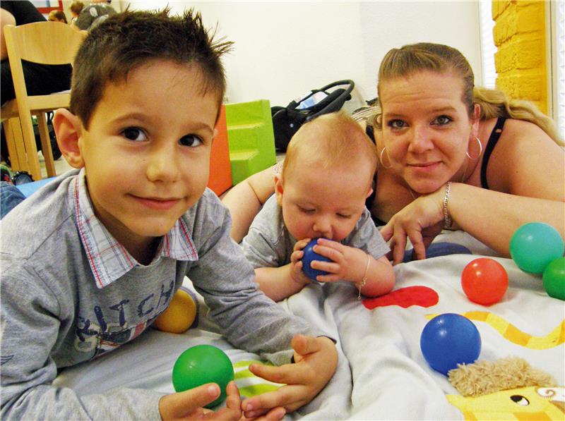 Das Bild zeigt zwei Kinder und ihre Mutter.