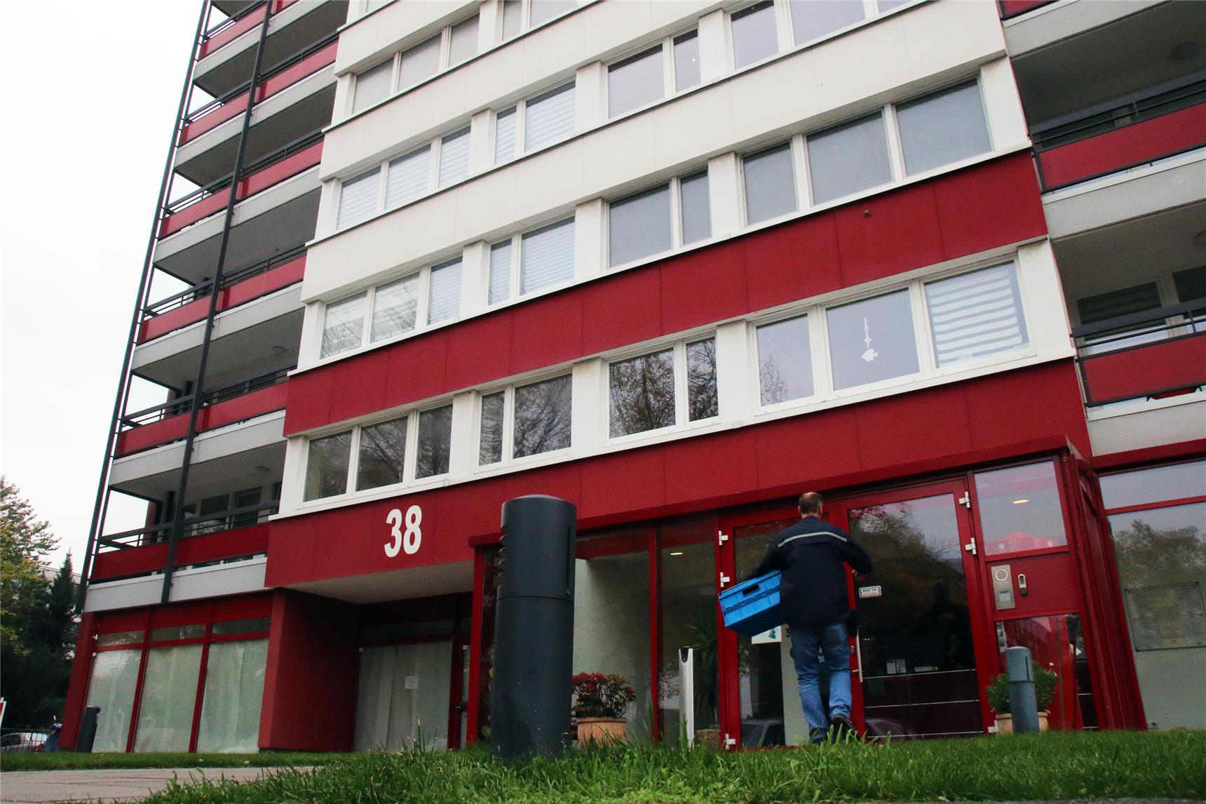 Ein 20stöckiges Hochhaus mit roten Balkonbrüstungen.