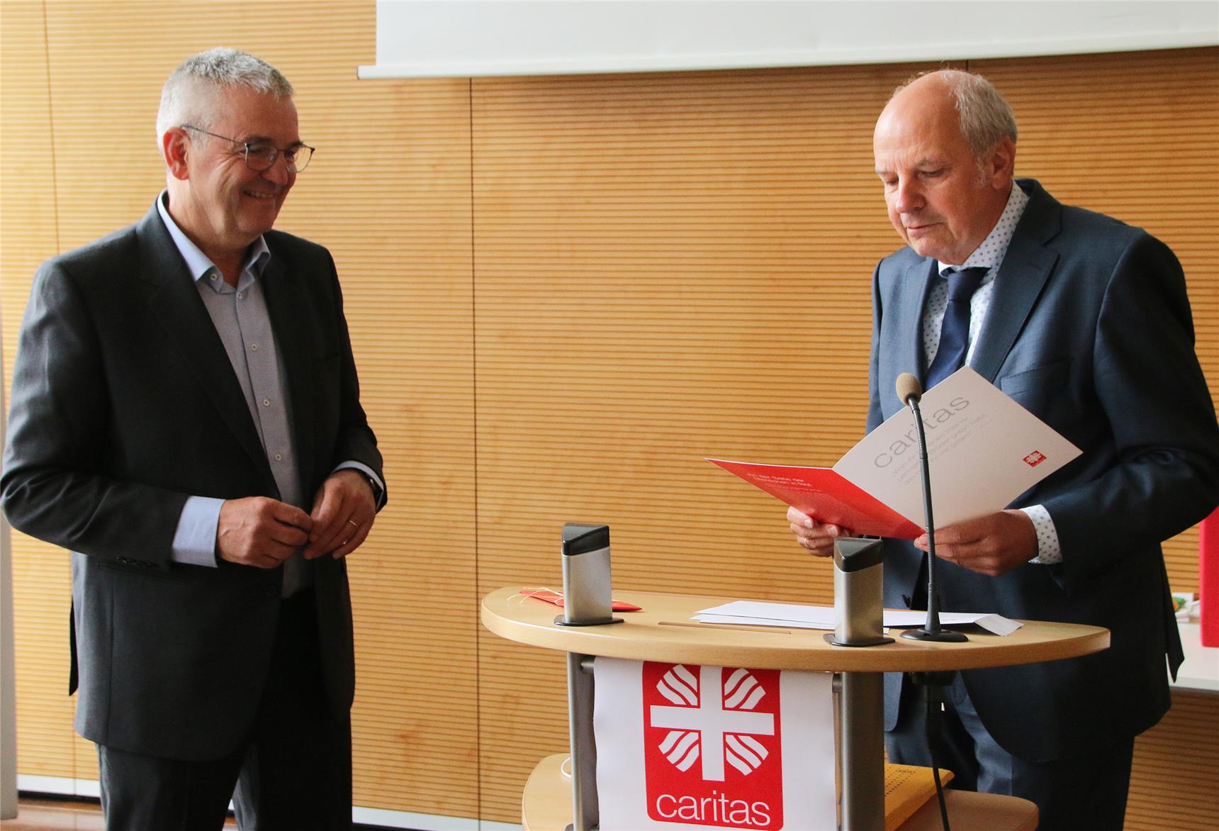 Das Foto zeigt zwei Männer an einem Stehpult.