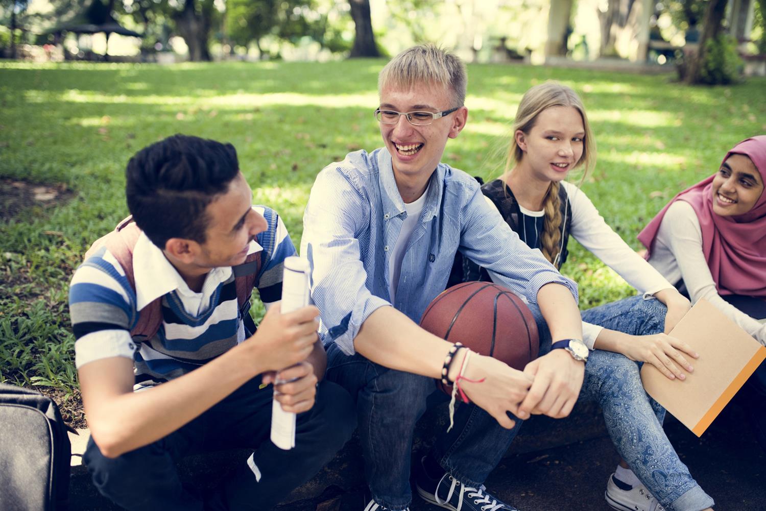 Eine Gruppe Jugendlicher im freundschaftlichen Gespräch unter freiem Himmel