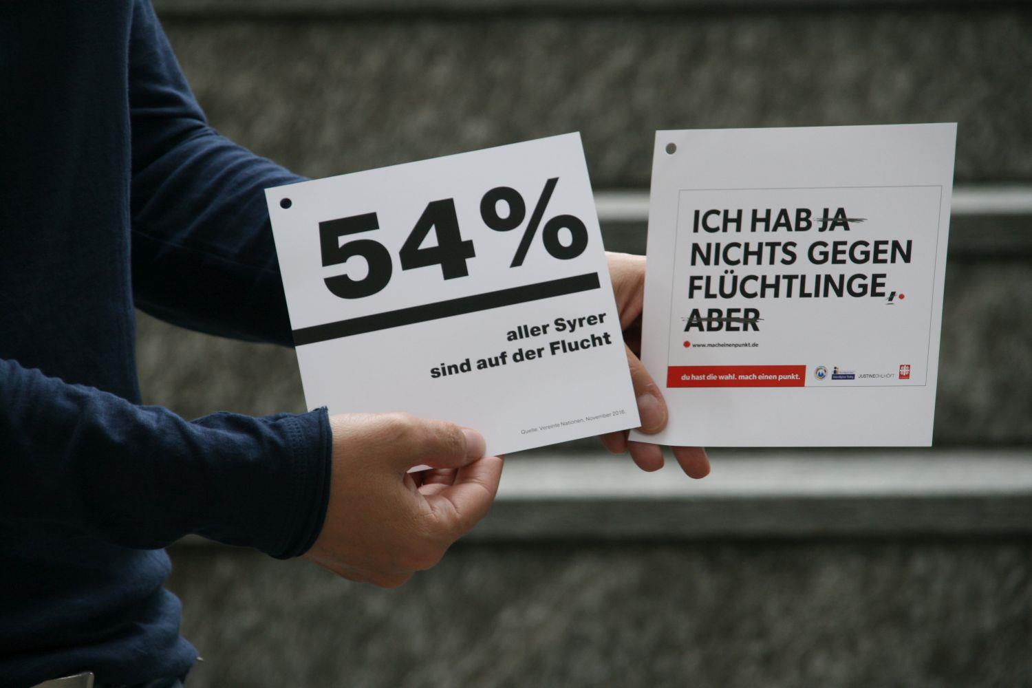 Mann hält zwei Infozettel zum Projekt 