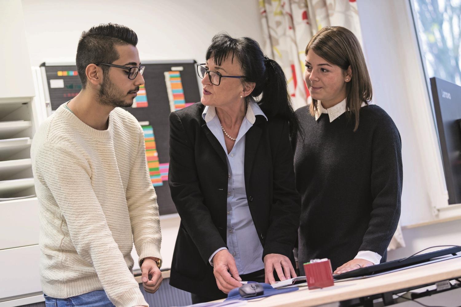 Abstimmung Azubi mit Ausbilderin im Büro.