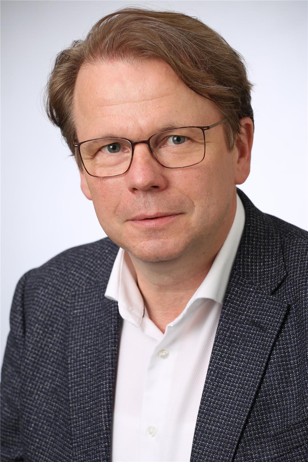 Portrait eines Mannes mit braunen Haaren und Brille