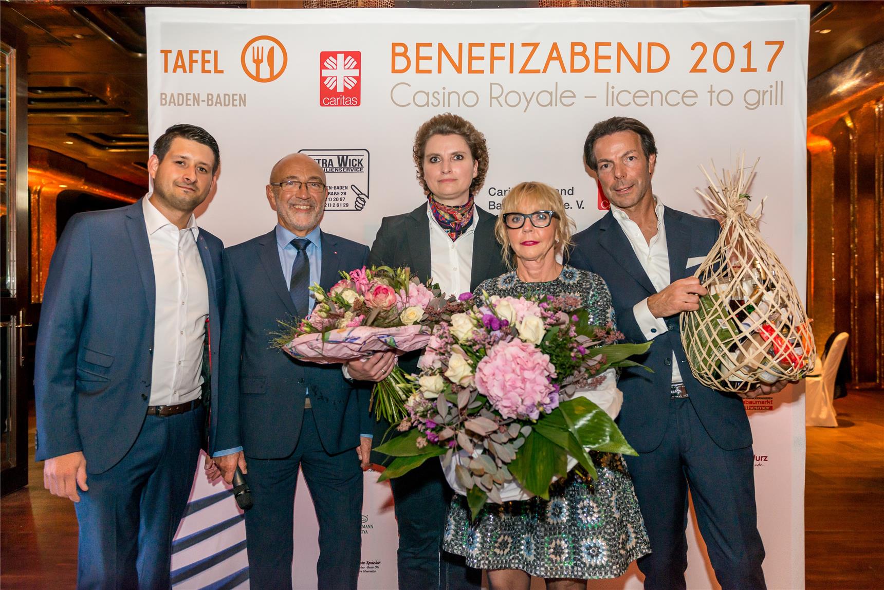 fünf stehende Personen mit Blumen