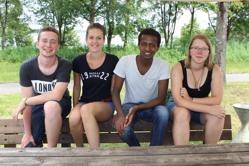 Fünf Freiwillige sitzen auf einer Bank