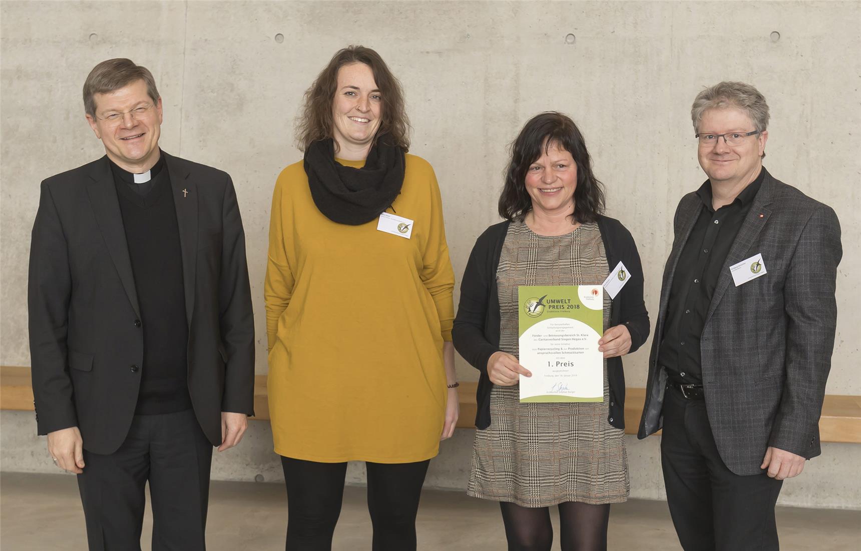 Zwei Männer und zwei Frauen mit Urkunde