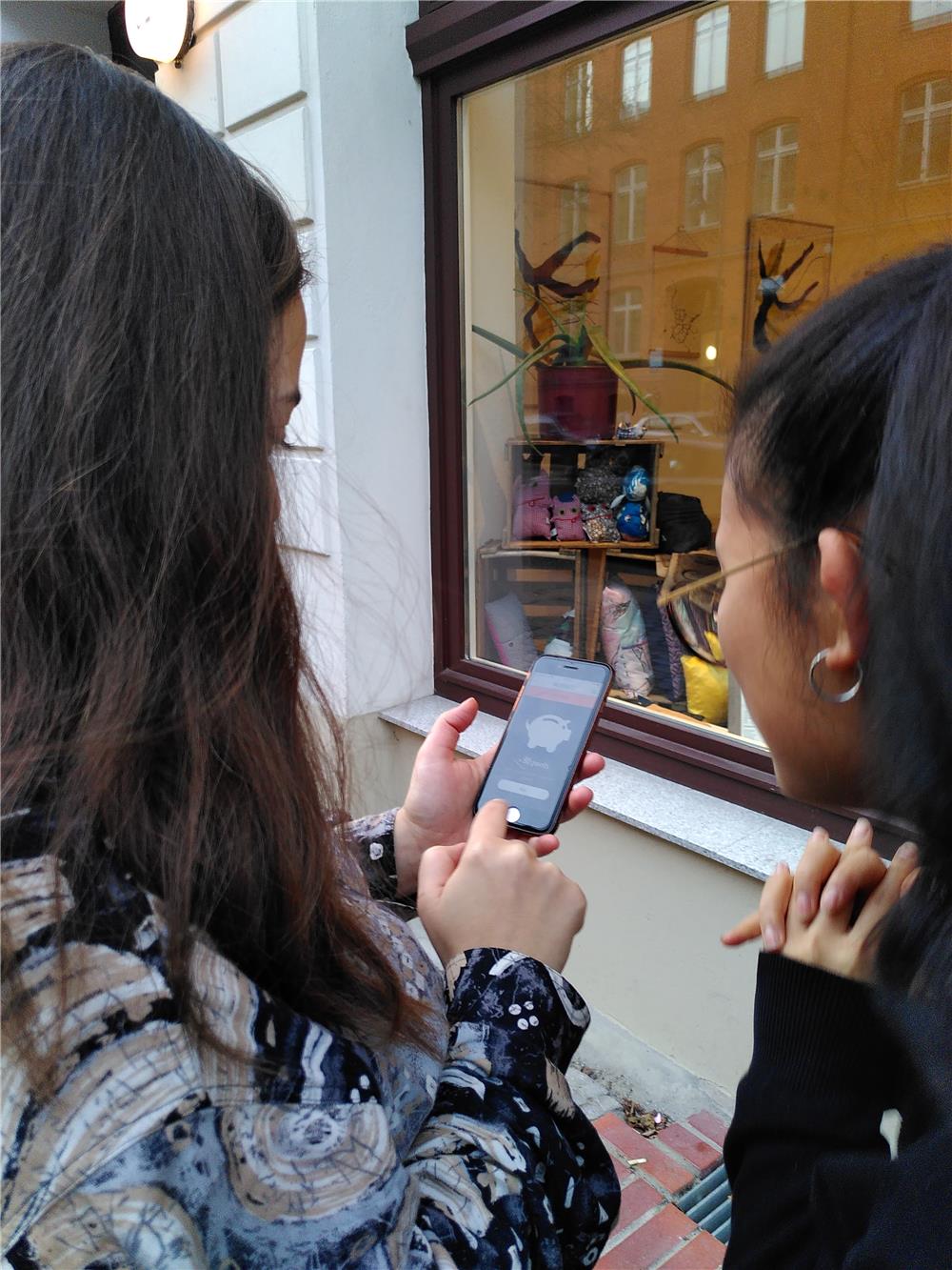 zwei Ehrenamtliche schauen auf das Smartphone