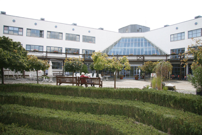 Blick über den Vorplatz des Altenheimes auf die Einrichtung mit gläserndem Vordach