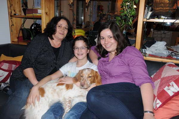 Junge mit seiner Ersatzfamilie und Hund auf Sofa