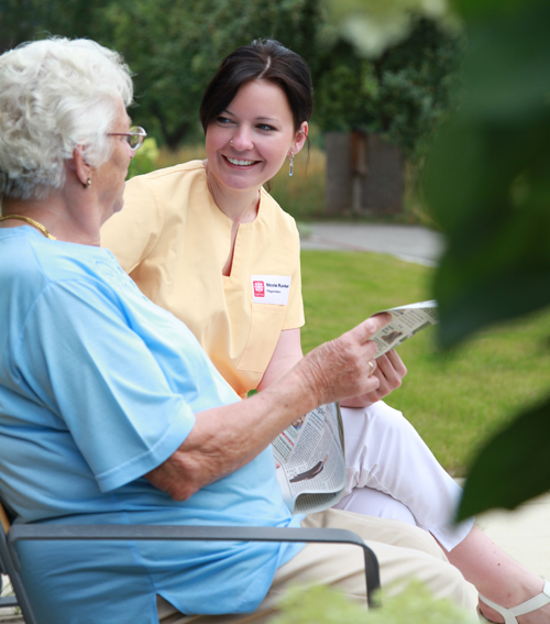 Pflegerin und alte Frau im Gespräch