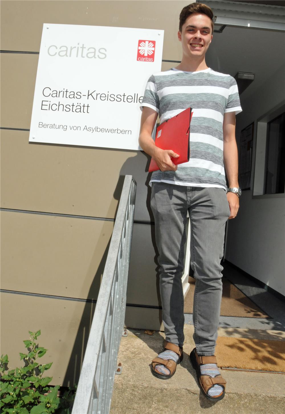 Junger Mann mit Mappe in der Hand