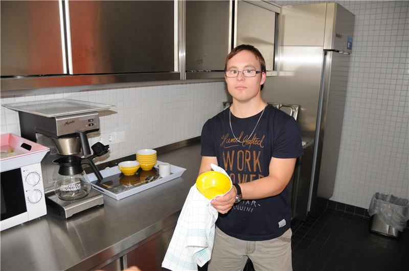 Mann wäscht Geschirr ab